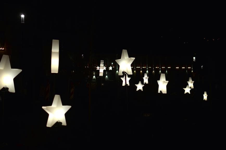 Eine Gruppe von Sternen leuchtet nachts vor einem Gebäude auf.